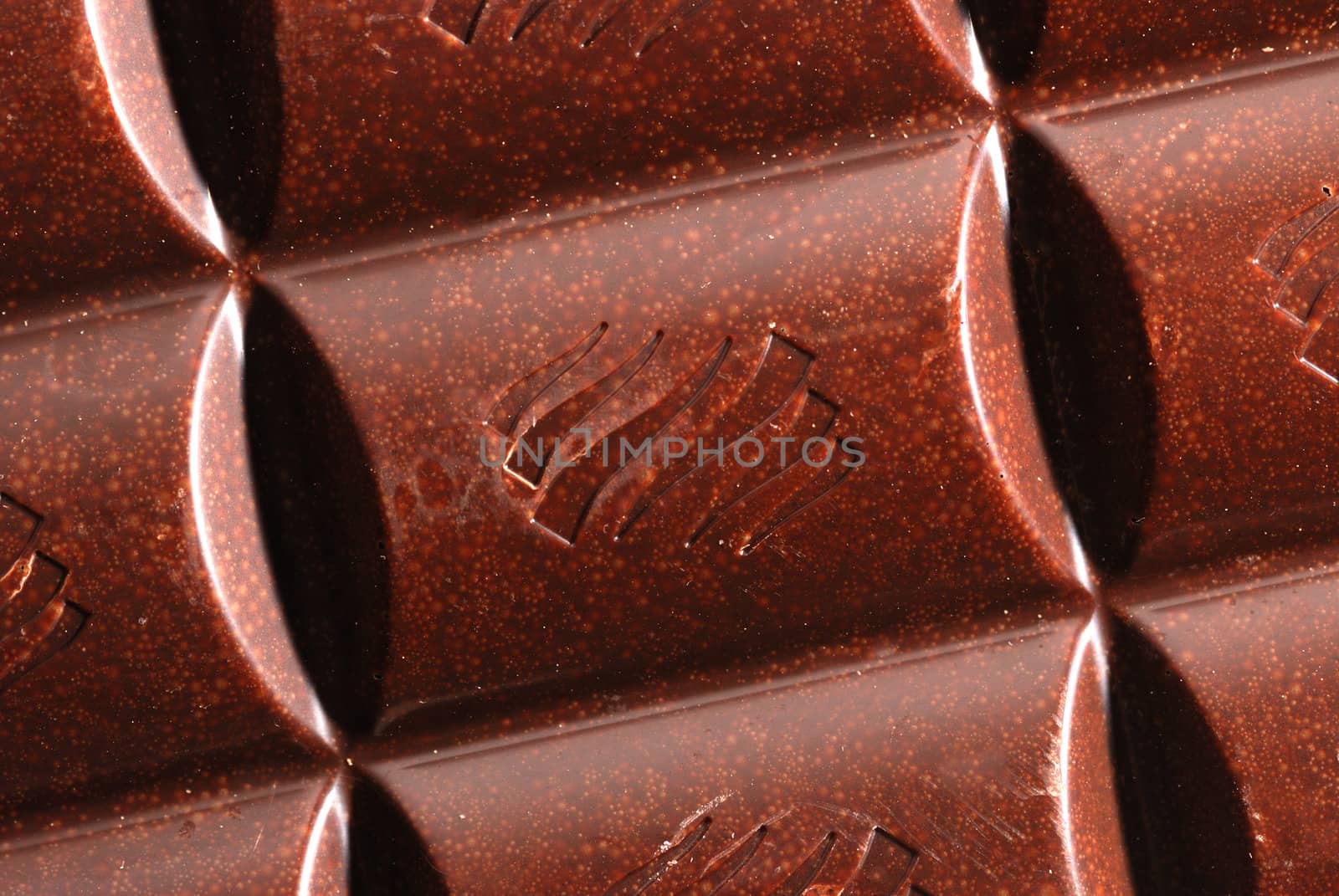 Chocolate. The broken tile of porous black chocolate