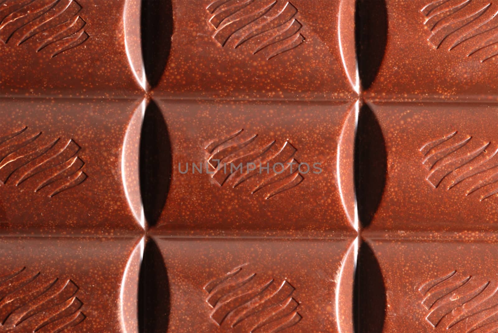 Chocolate. The broken tile of porous black chocolate
