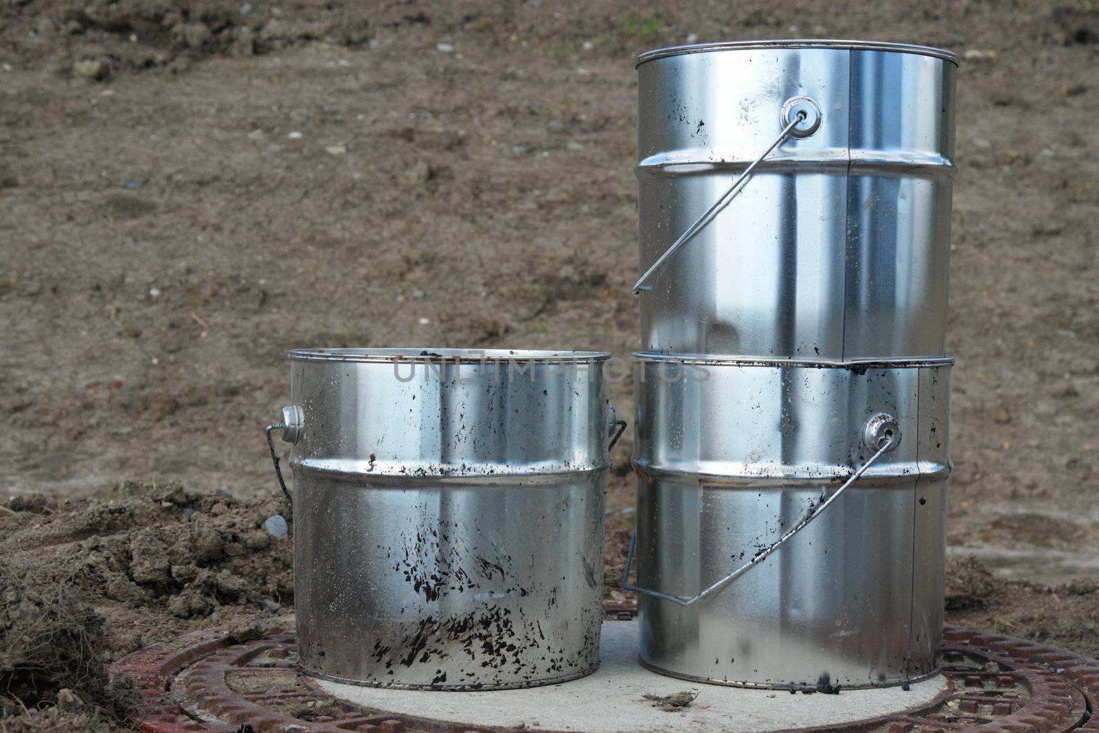 metal silver cans on ground on a building site