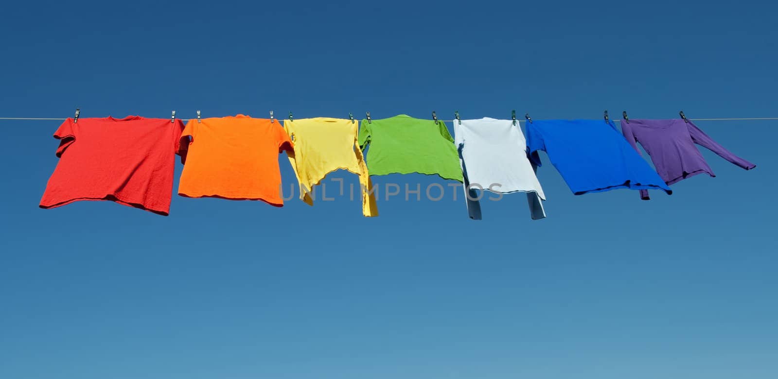 Rainbow laundry, bright shirts on a clothesline by anikasalsera
