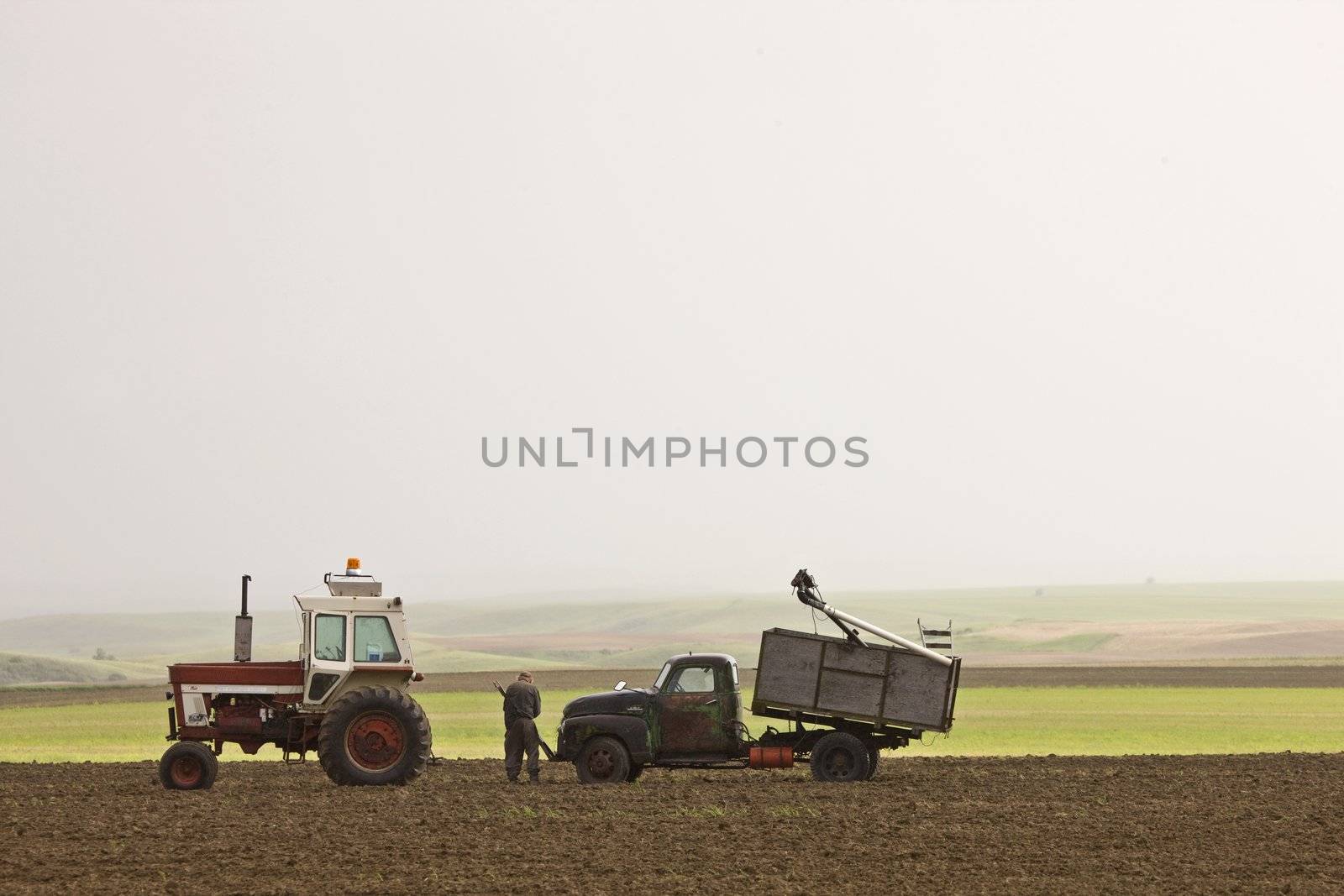 Old Farmer working on Farm Vehicles by pictureguy