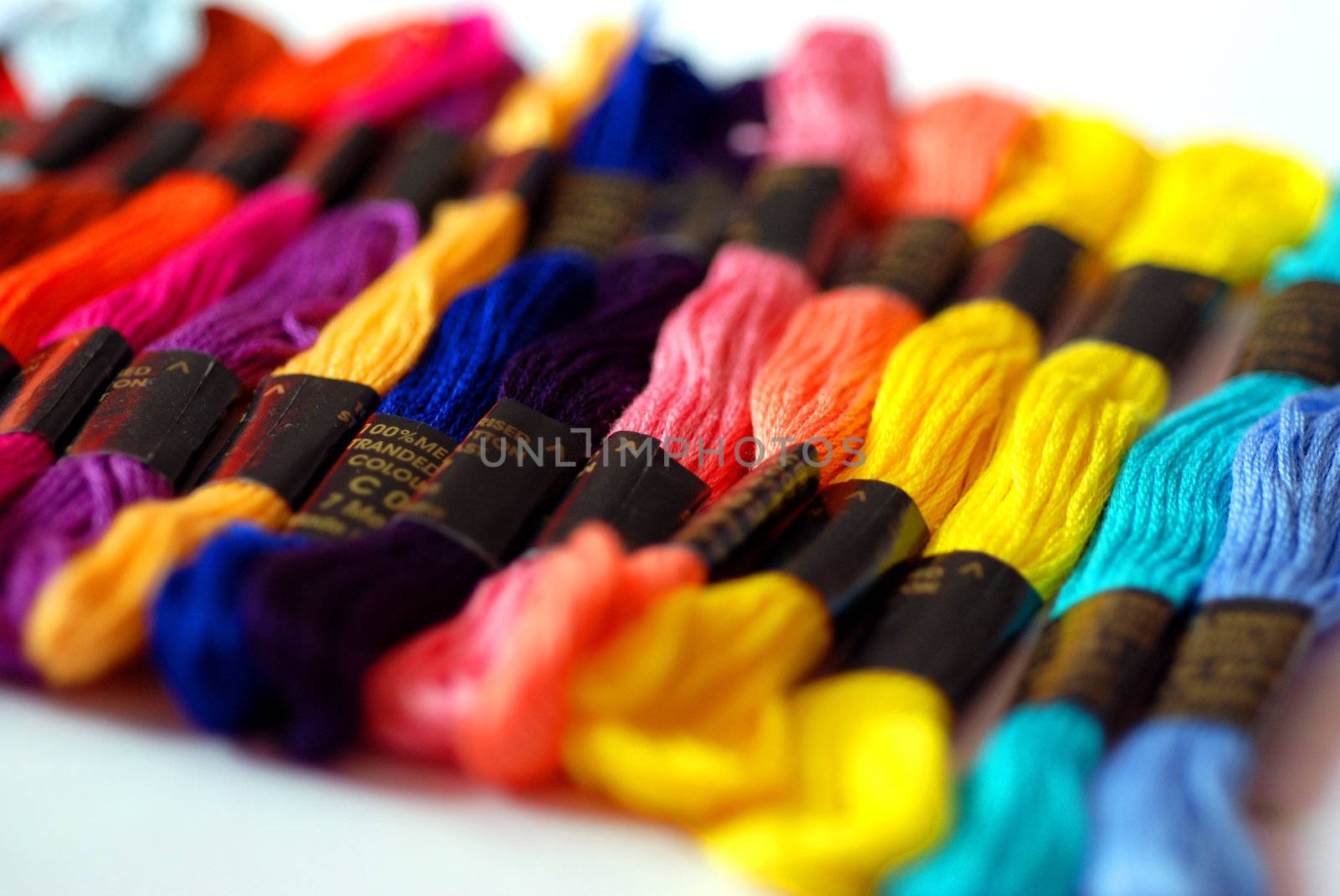 Brightly coloured embroidery threads lined up in a row