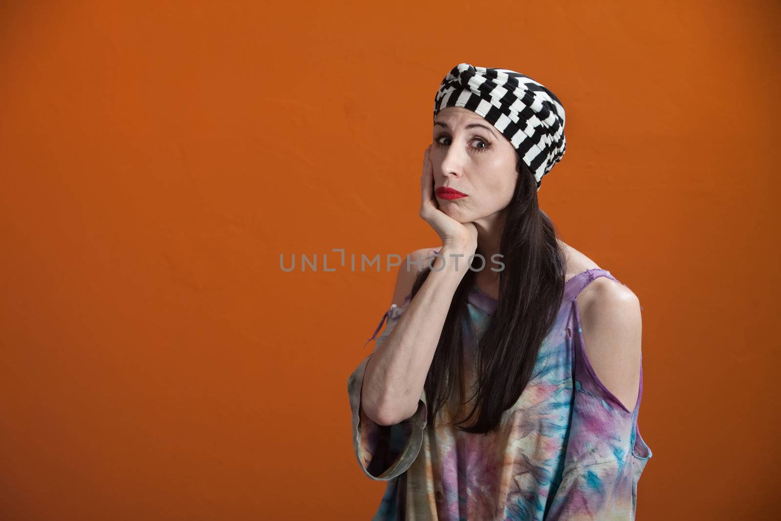 Mexican American woman wearing a tie-dye shirt in a misarable mood