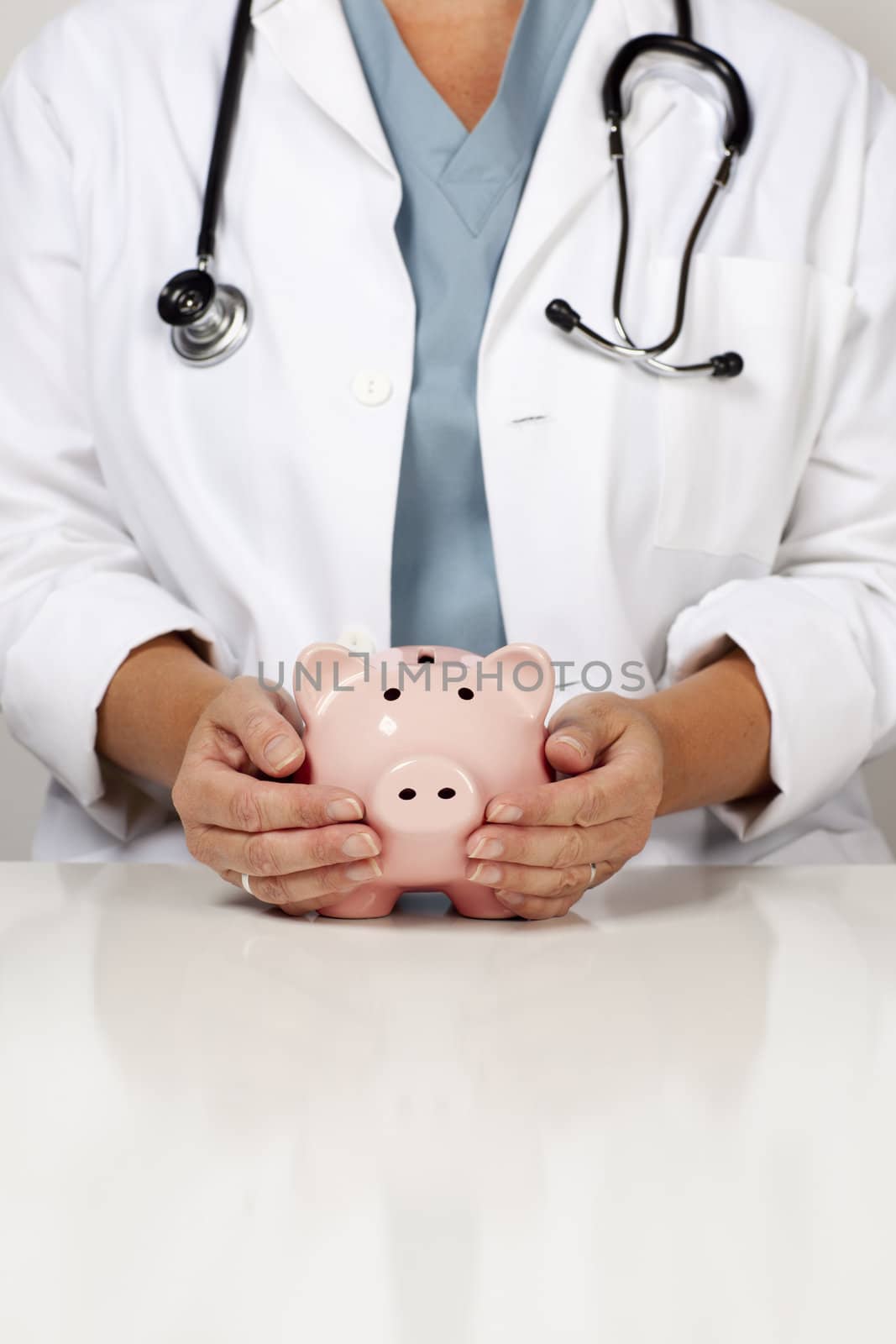 Female Doctor with Caring Hands on a Piggy Bank.