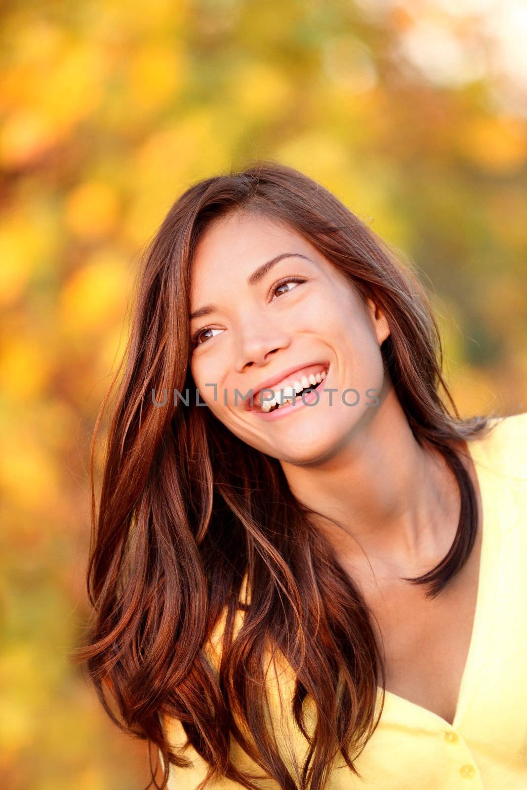 Fall woman smiling - Autumn portrait of happy lovely and beautiful mixed race Asian Caucasian young woman in forest in fall colors.