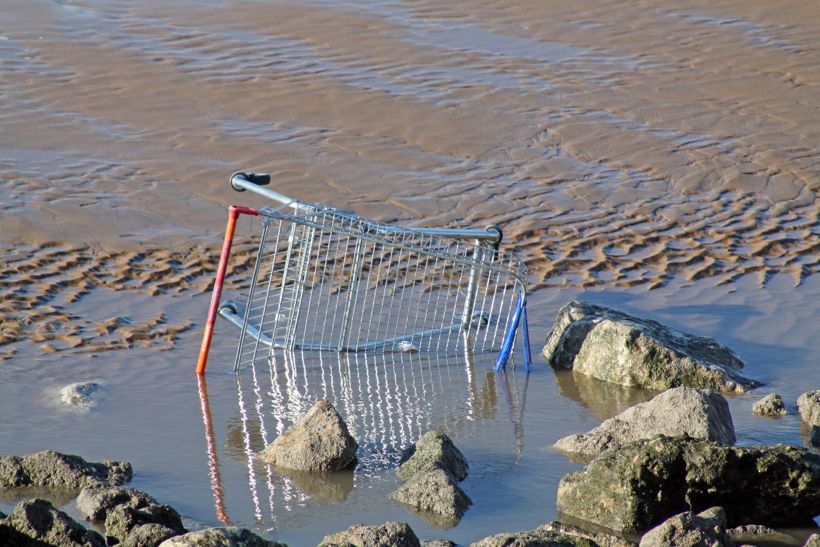 disguarded shopping trolly on blackpool beach