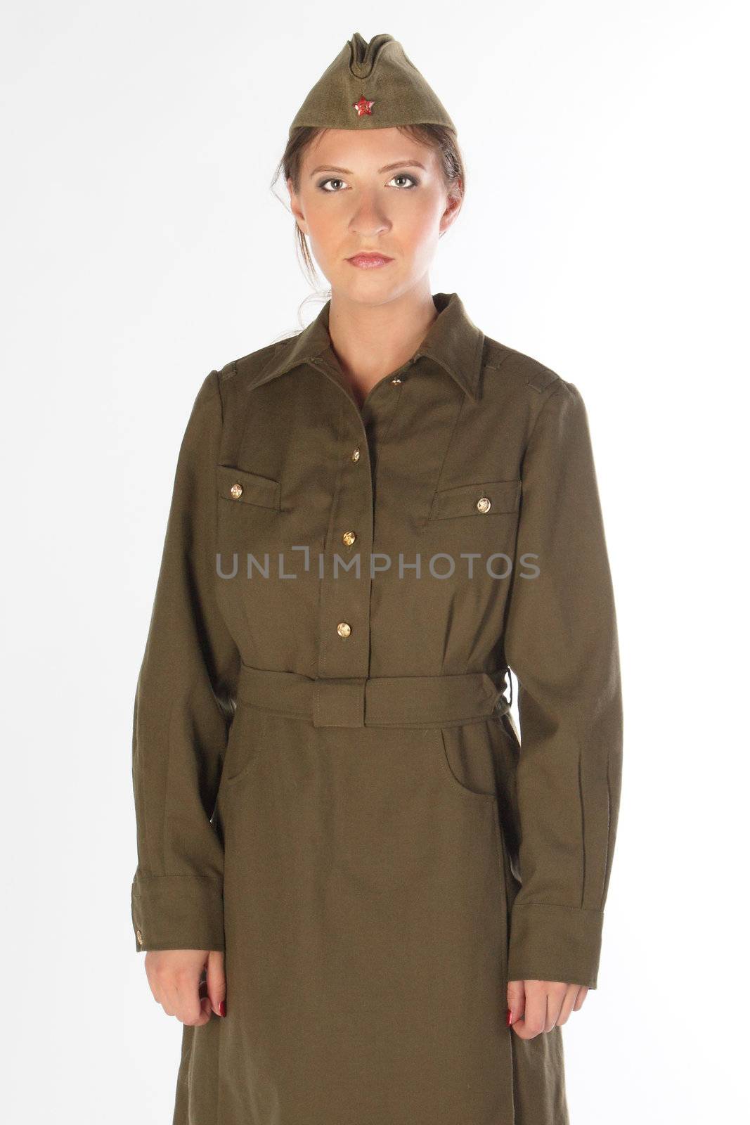 The young and beautiful girl in a military dress and a field cap