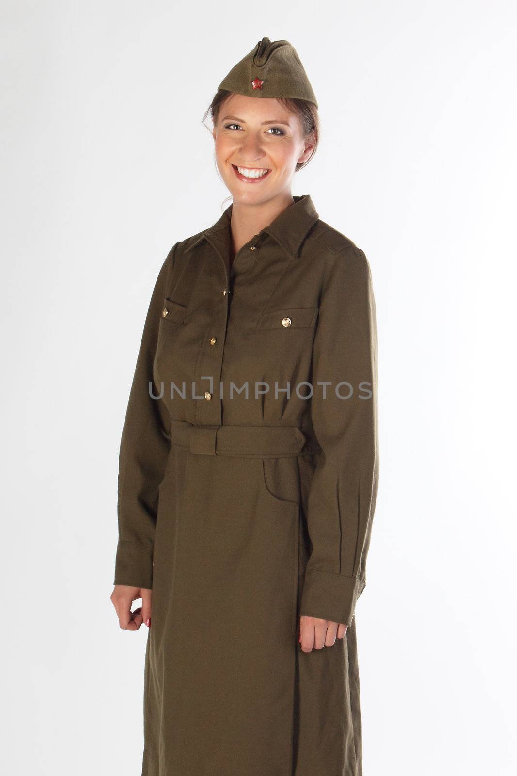 The young and beautiful girl in a military dress and a field cap