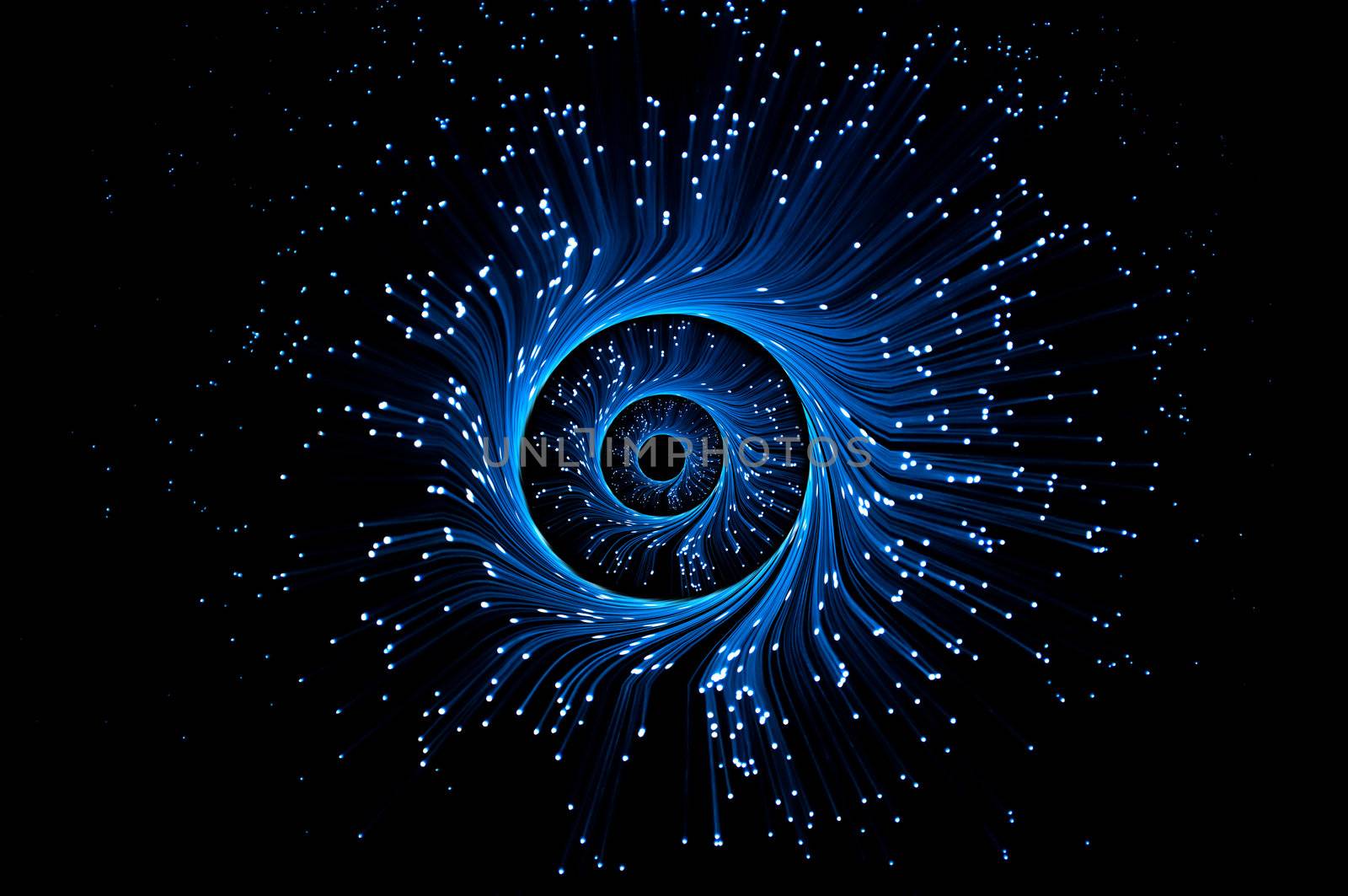 Illuminted blue fibre optic light strands forming three swirling rings against a black blackground.