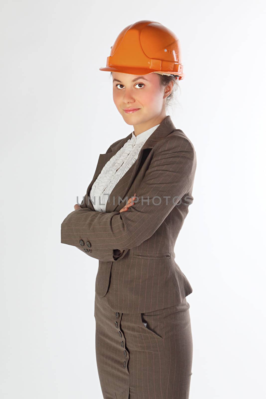 The young and beautiful girl in a business suit and a building helmet