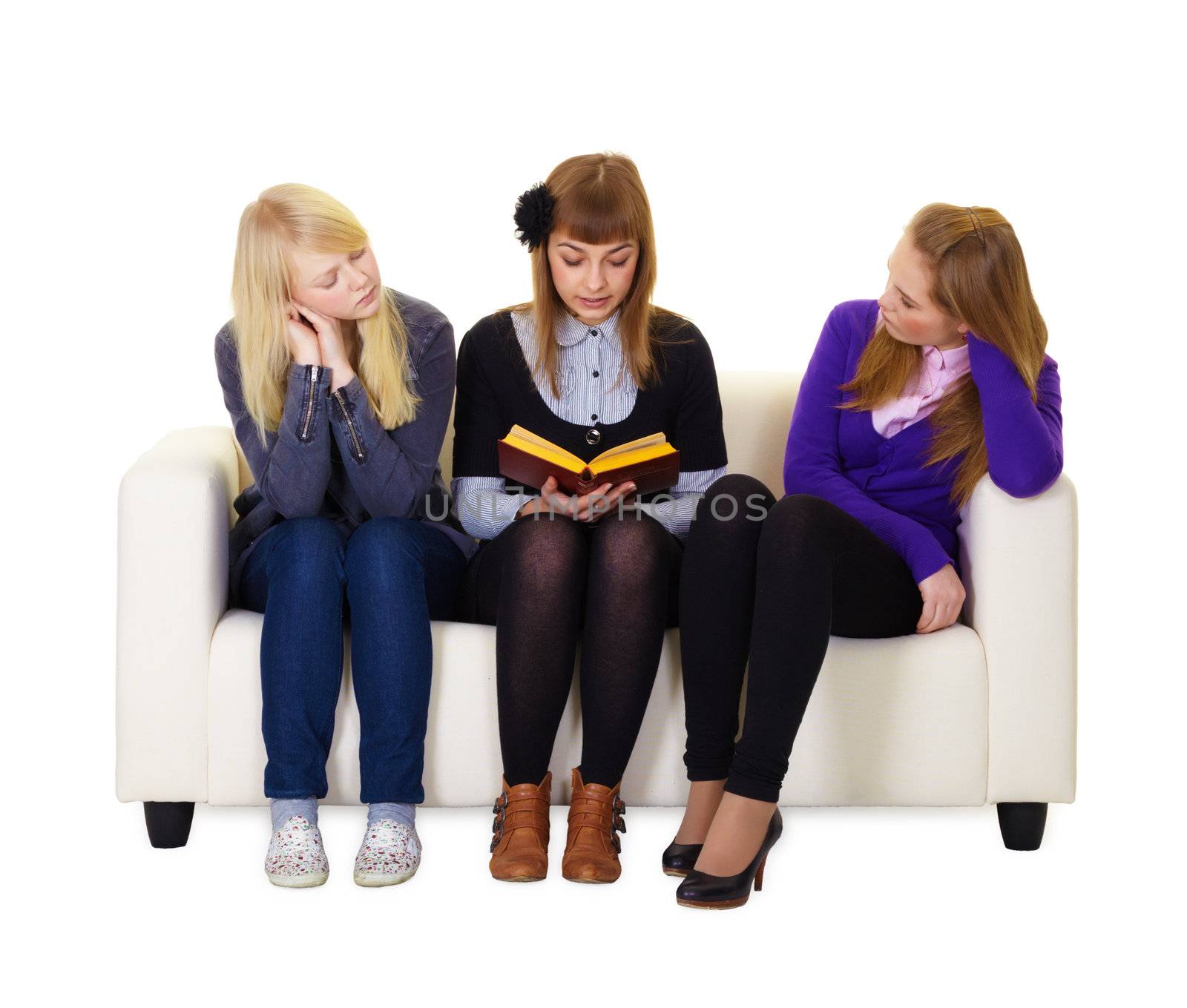 Teen girl reading a book to her friends sitting on the couch
