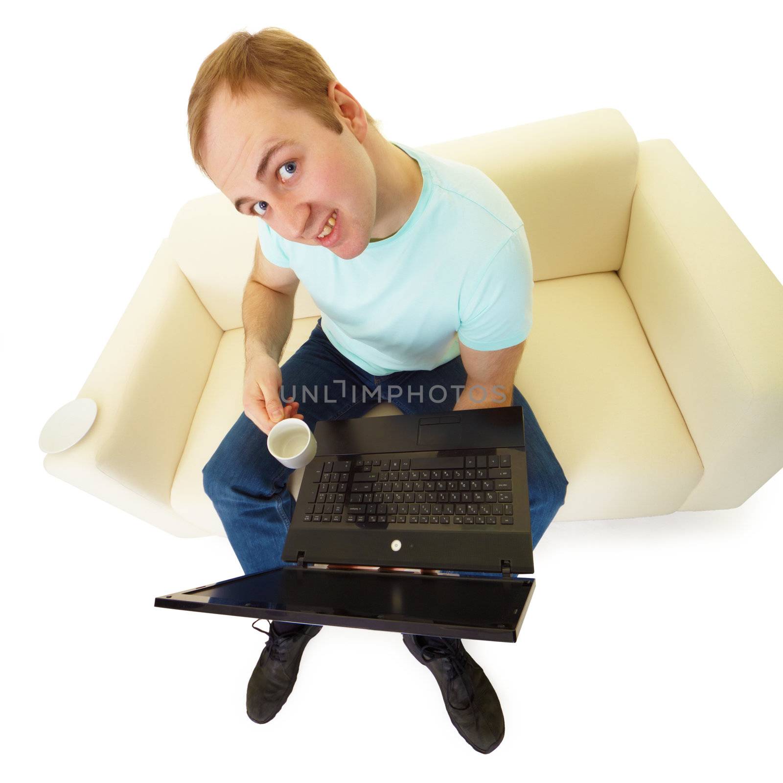comical emotional man with a laptop and a cup of coffee sitting on the couch
