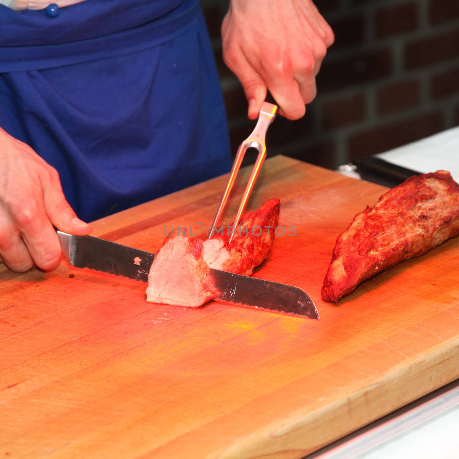 A cook cuts meat at the buffet - square
