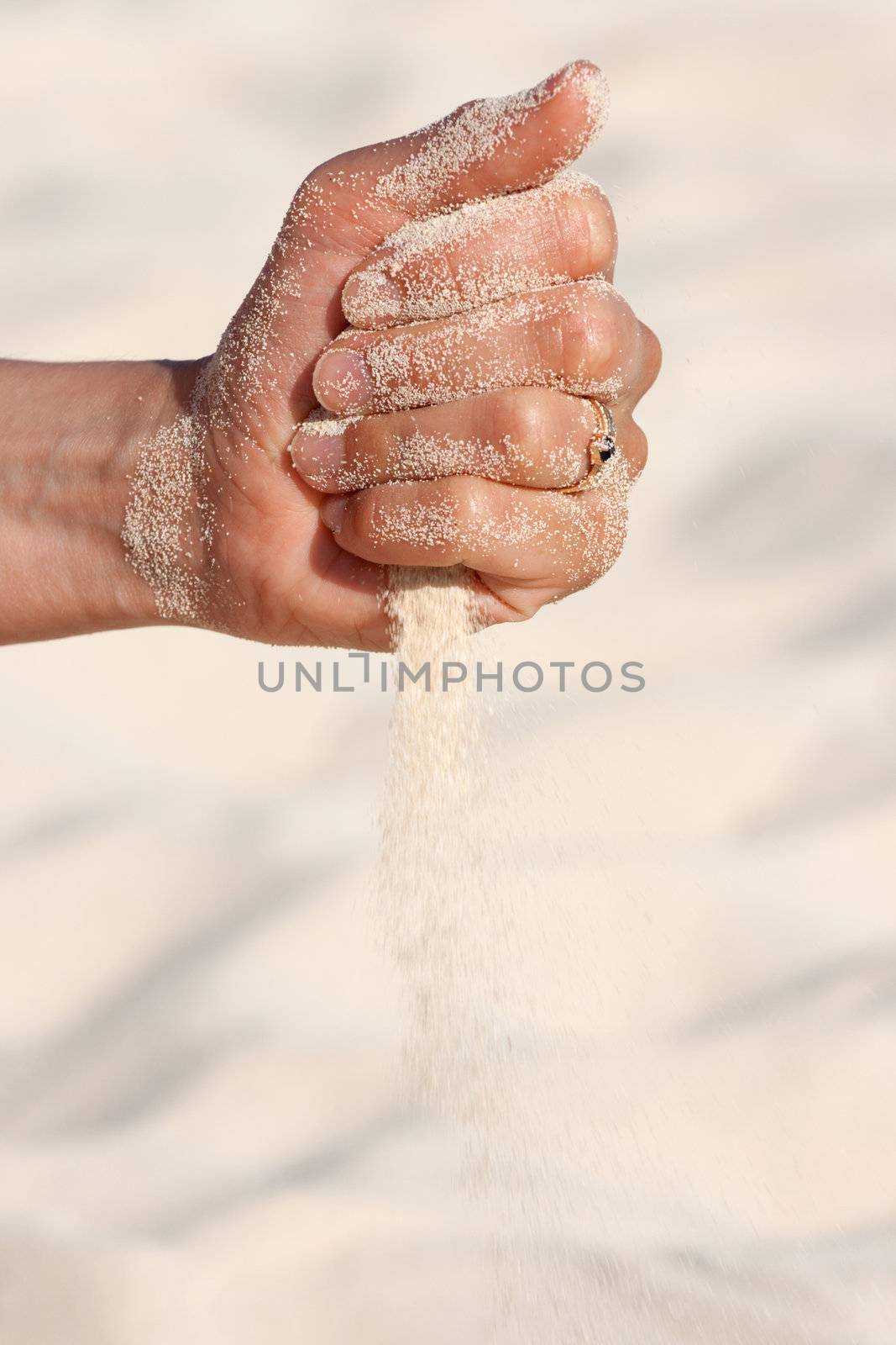 Sand running through hands n beach