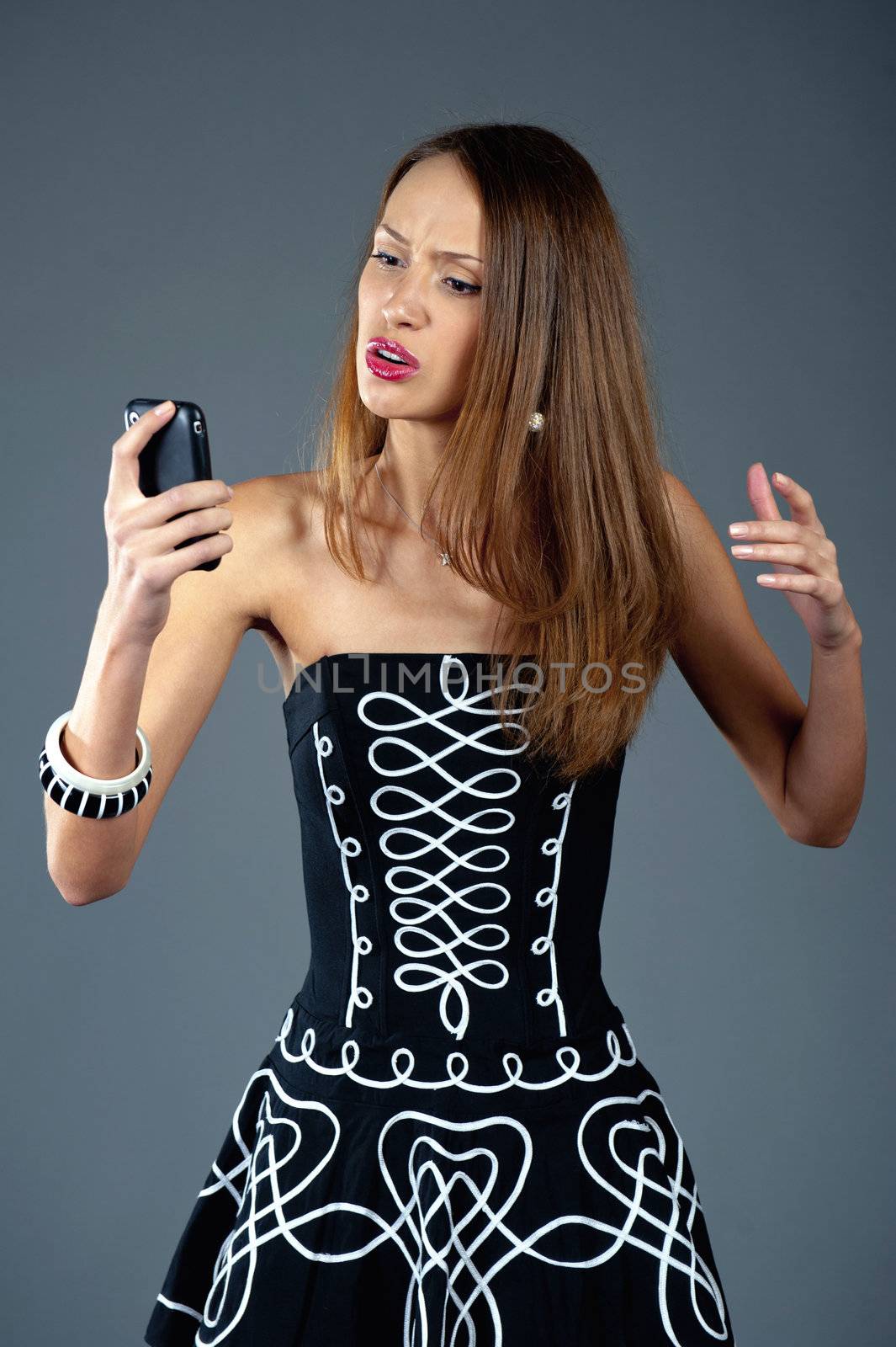 The beautiful surprised model looks in phone