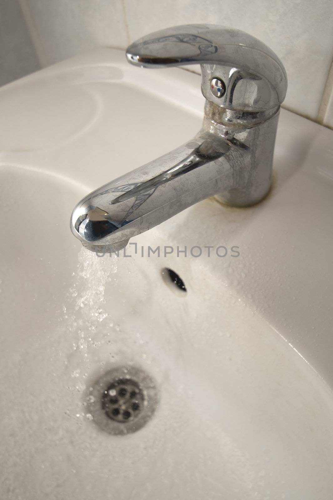 white wash basin with chrome faucet detail photo