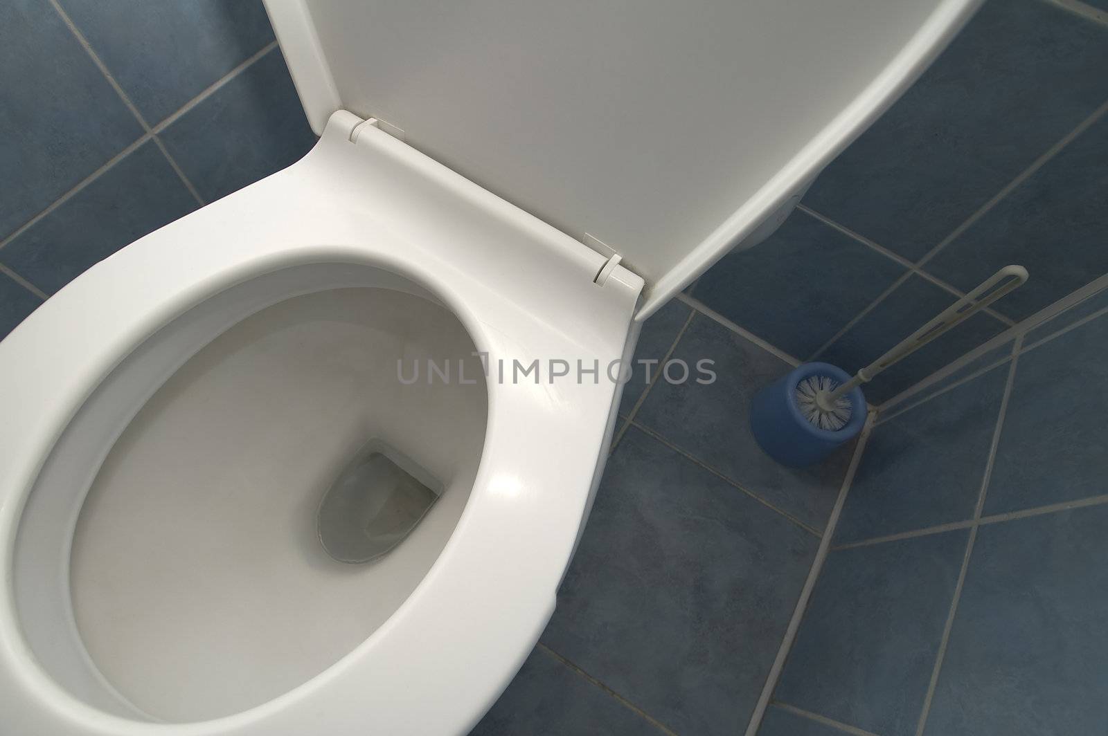 white clean toilet detail photo, blue tiled floor and walls
