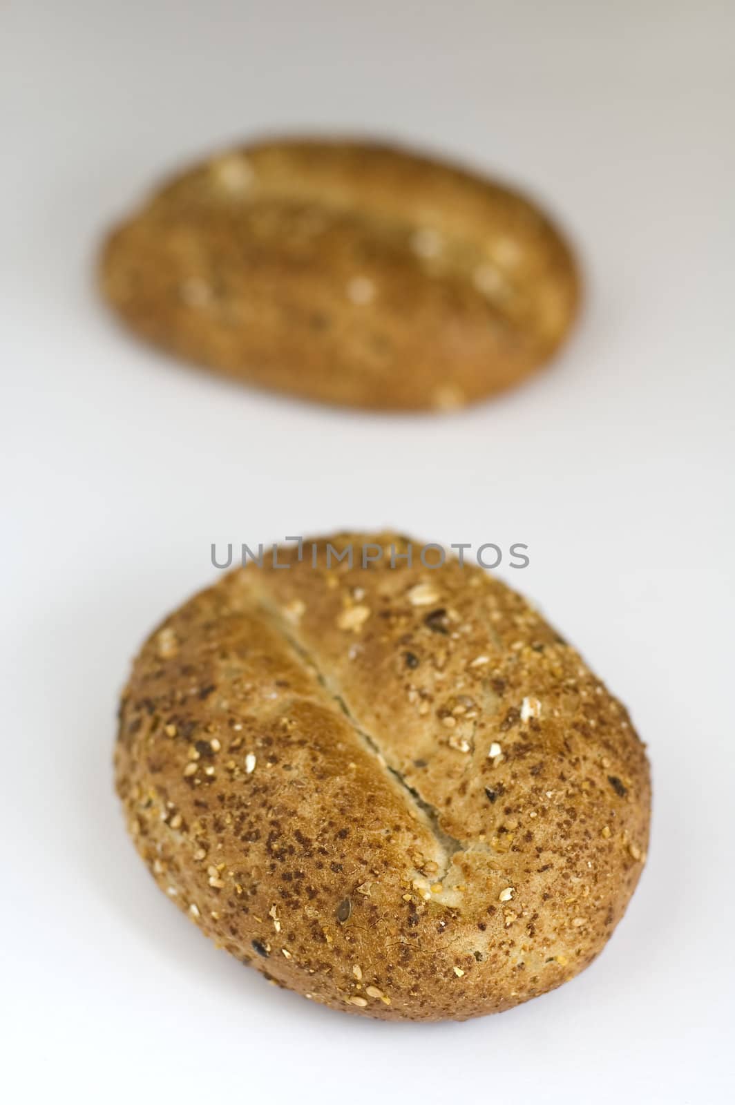two small baked cereal bun on white photo, shallow depth of view