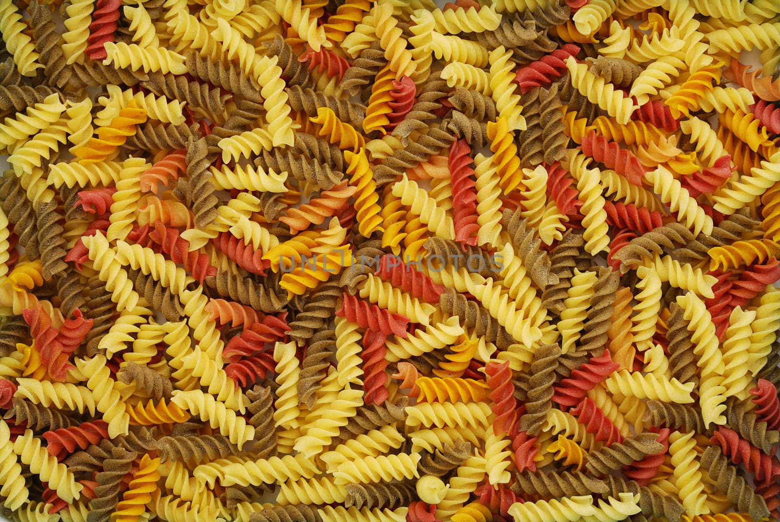Multicolored dry fusilli pasta background