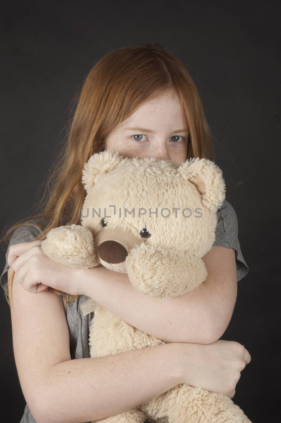 young girl is cuddling with a teddybear