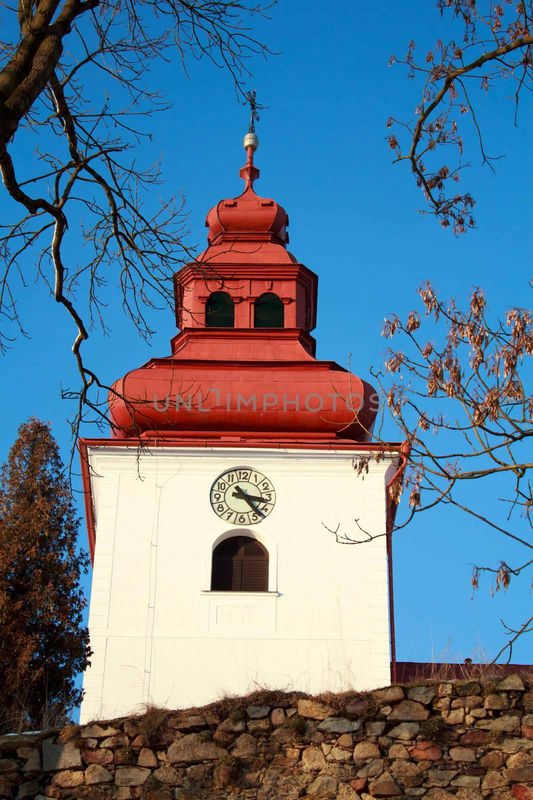 Catholic church with steeple clock and blue sky