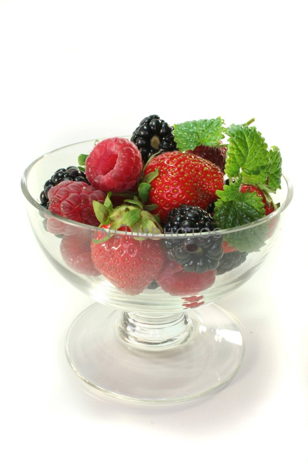 fresh berries in a small bowl with lemon balm