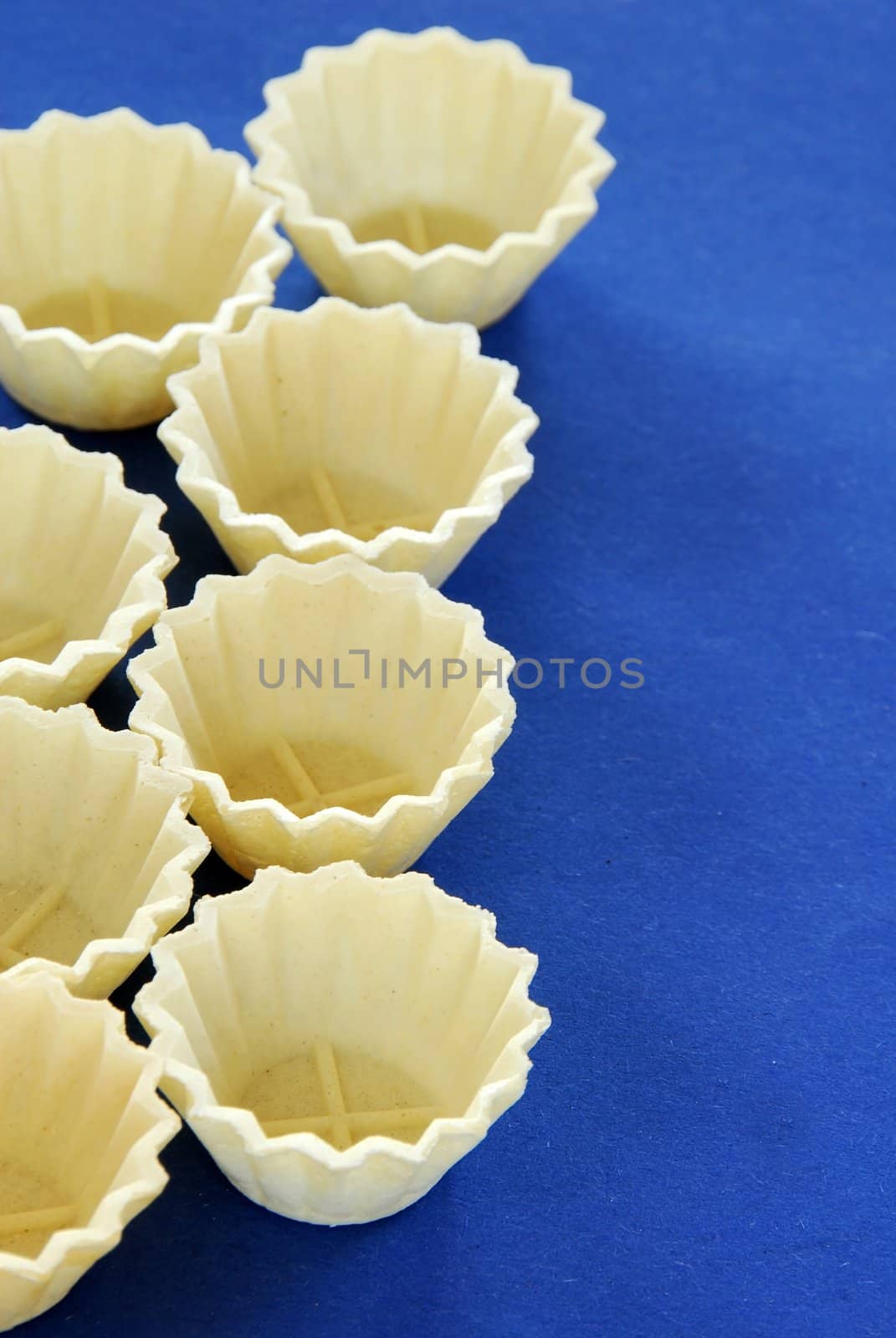 rows of empty small edible treats for decorative cookies over blue background