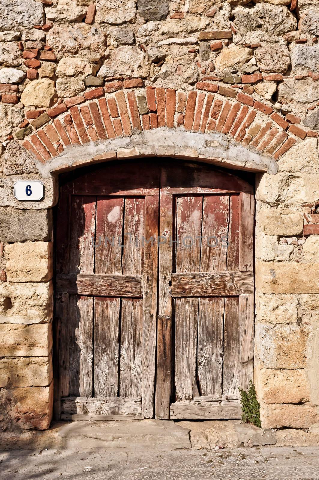 Old wooden door in an old brick wall by martinm303