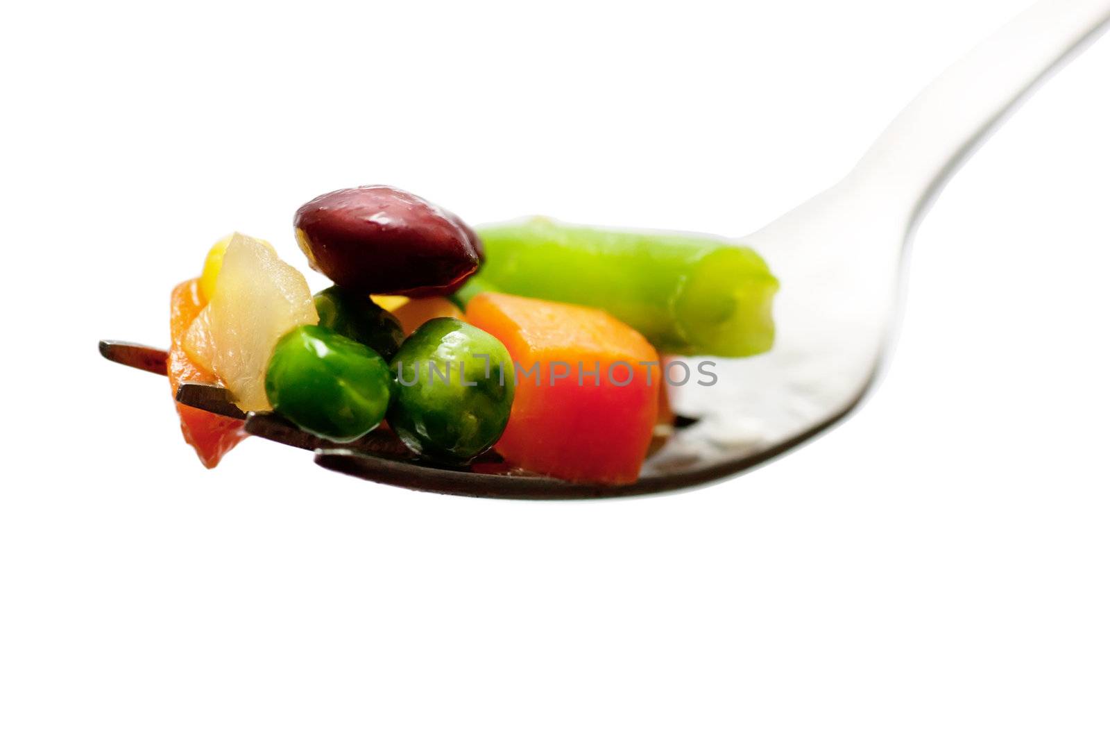 Pieces of boiled vegetables on a fork isolated over white