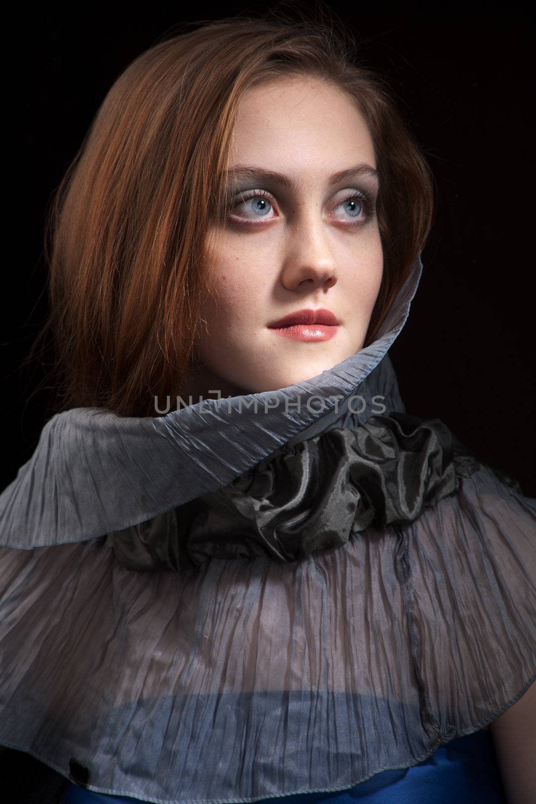 Romantic portrait of a redhead beautyful girl in studio over black