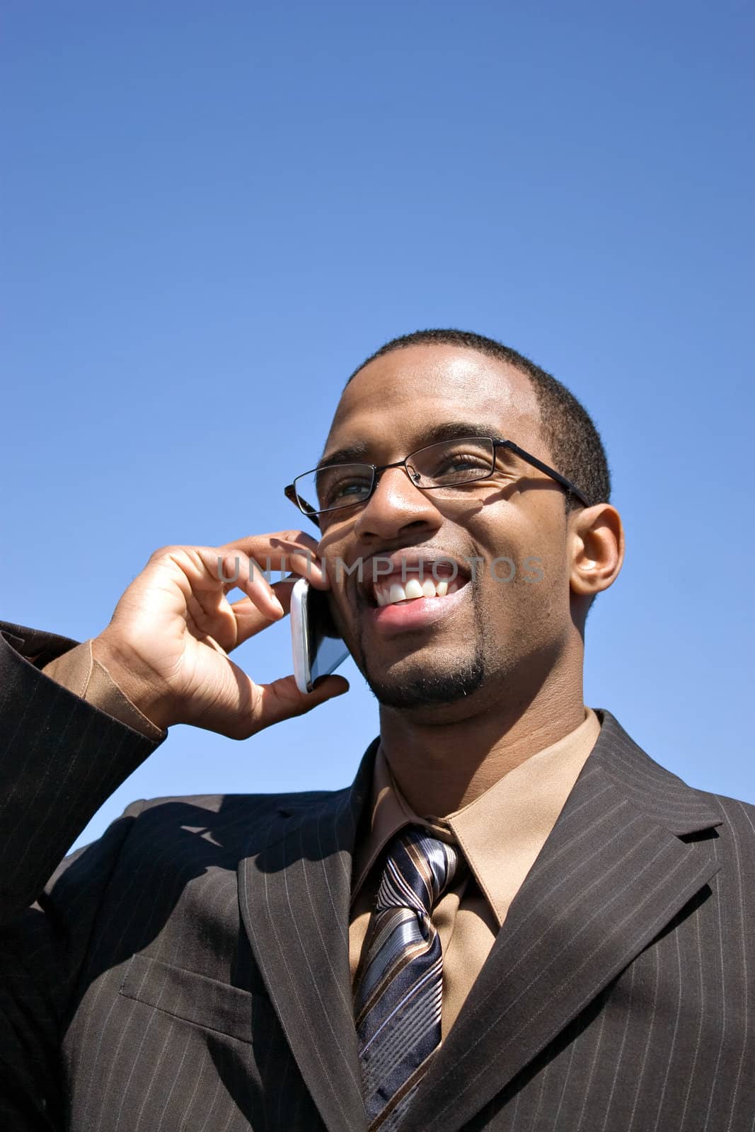 A young business professional talking on his wireless mobile phone.