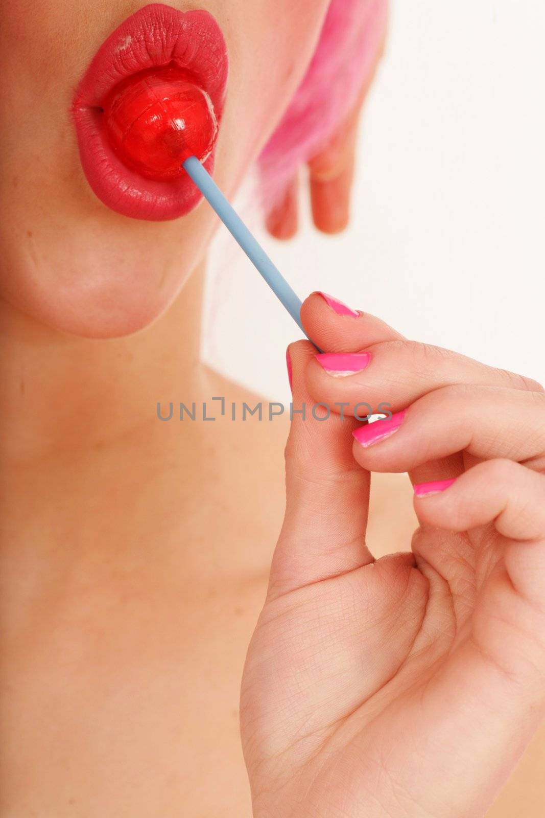 close-up of a red lollipop on pink lips
