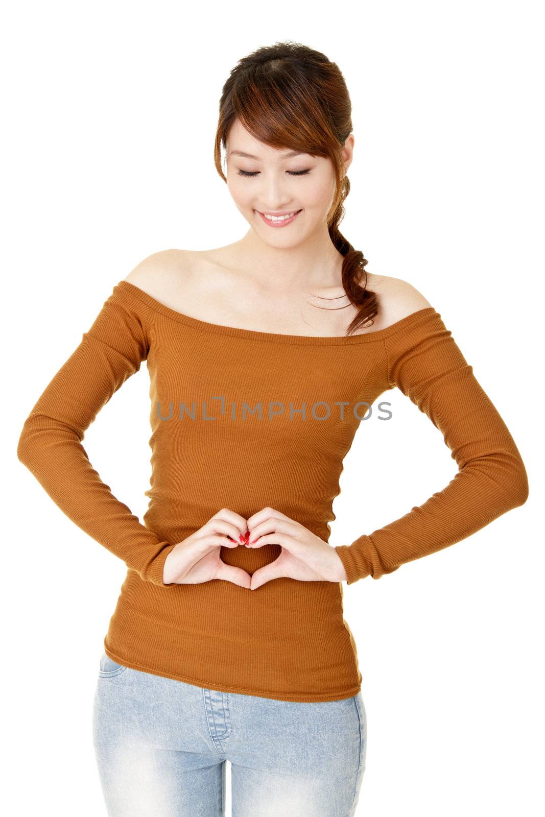 Smiling woman make heart shape on her belly.