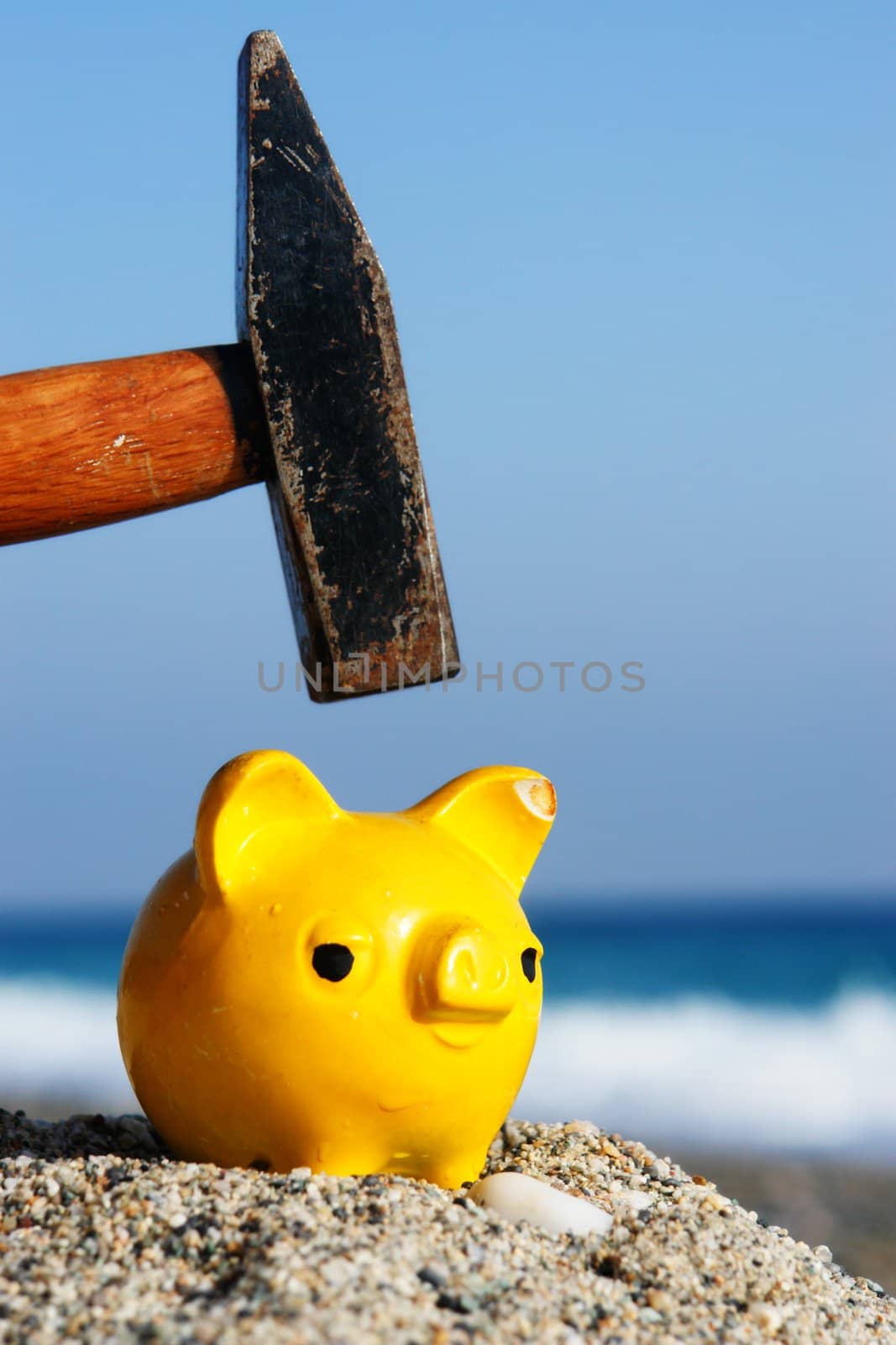 closev up of yellow piggybank with hammer