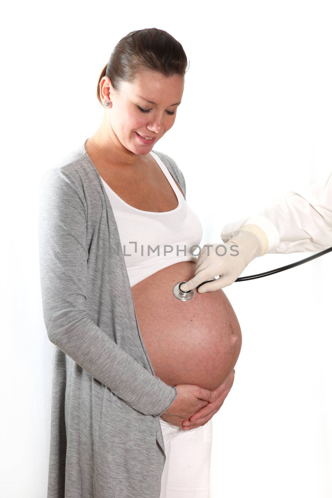 doctor with stethoscope examining the abdomen of a pregnant woman
 