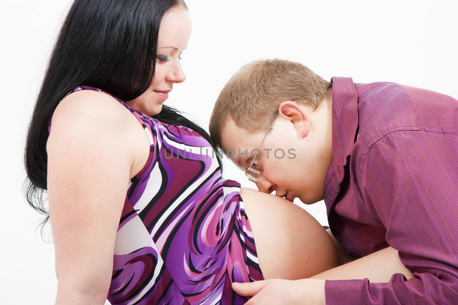 young man kissing the stomach pregnant wife
