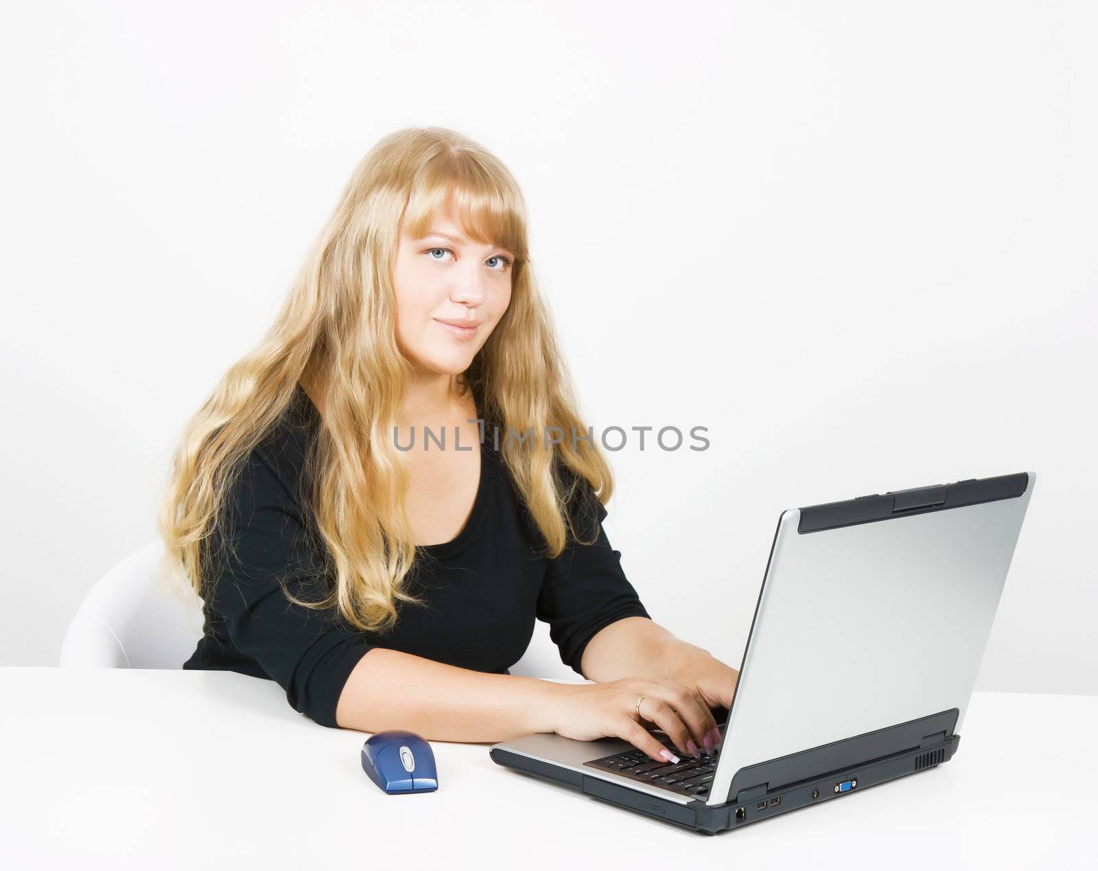 young girl working on laptop in a bright room