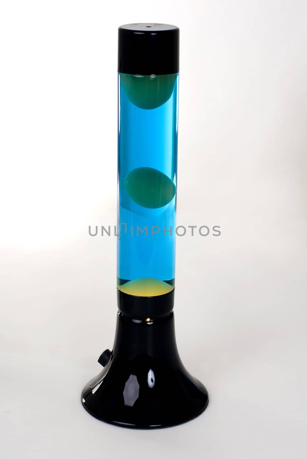 A Black lava lamp with blue liquid and green lava isolated on a white background. 