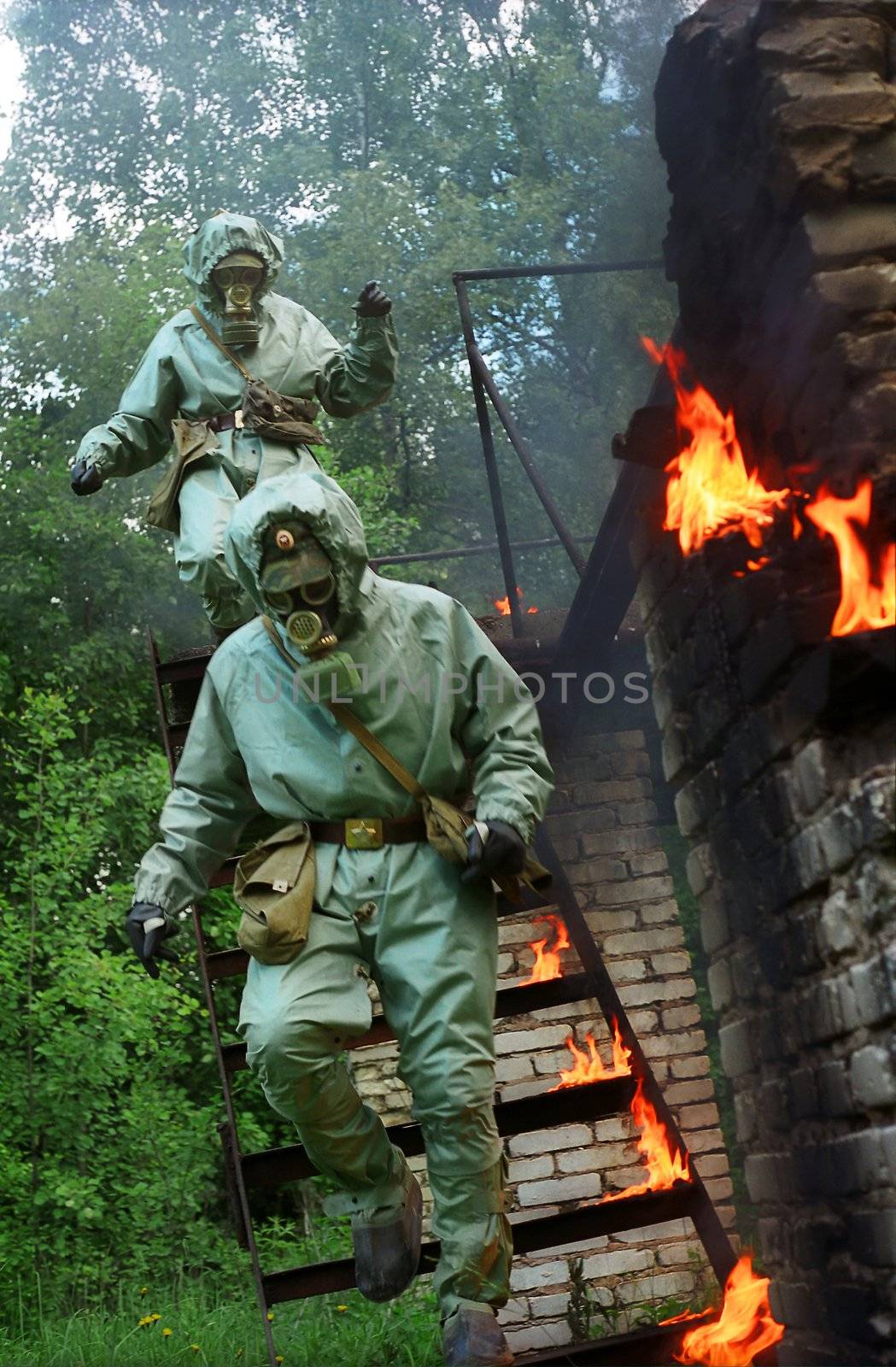 two men in gas-masks running downstairs with the fire near them