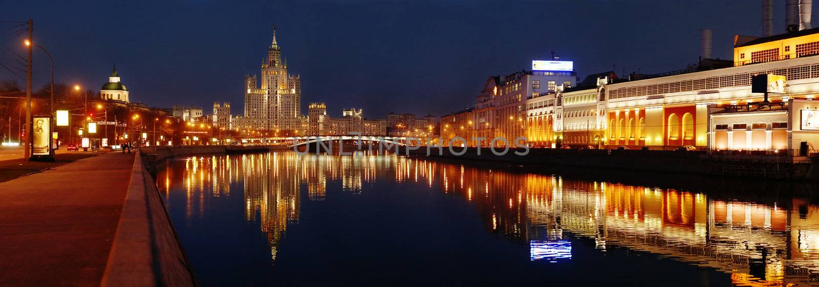 panoramic photo of a night city on a bank of a river