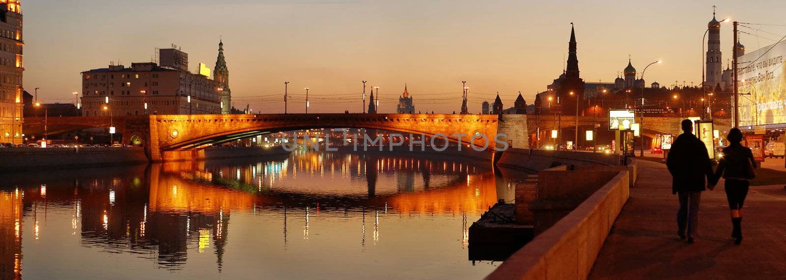 panoramic photo of a night city on a bank of a river