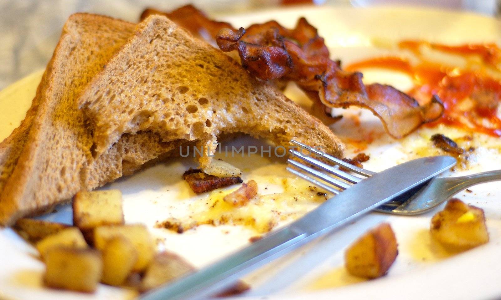 "Part of a complete breakfast" a play on words on the popular catchphrase with cereal commercials.  Home fries, toast, bacon and eggs.