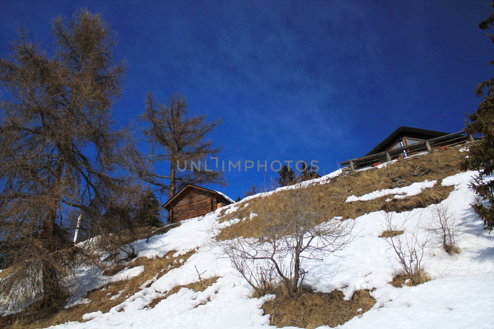 Small wood chalet in the Alps mountain by beautiful winter day, Switzerland