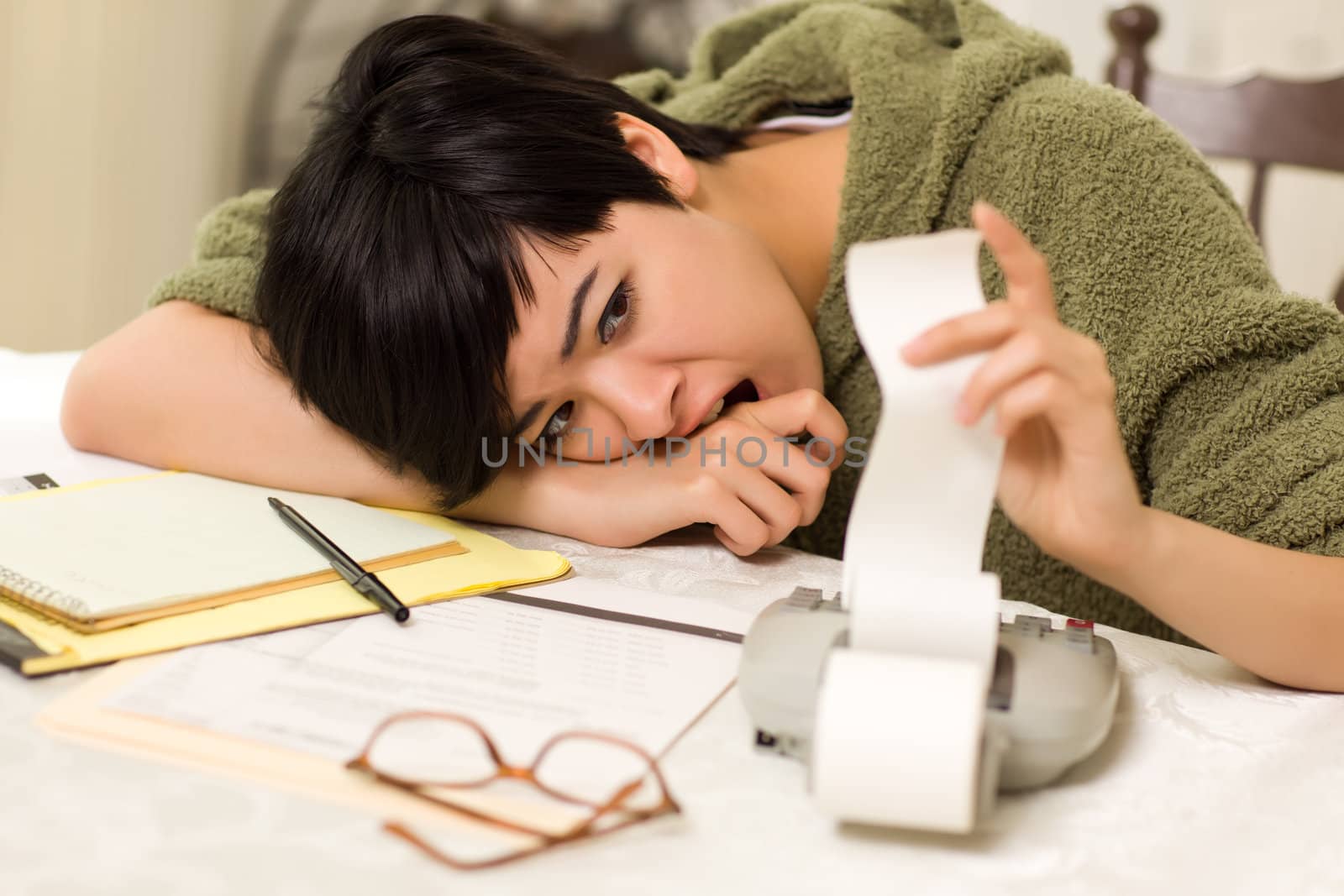 Multi-ethnic Young Woman Agonizing Over Financial Calculations in Her Kitchen.