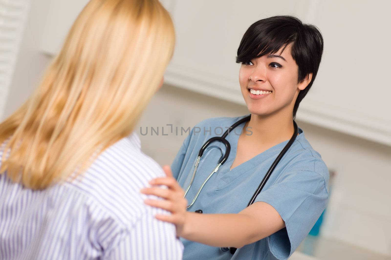 Attractive Multi-ethnic Young Female Doctor Talking with Patient by Feverpitched