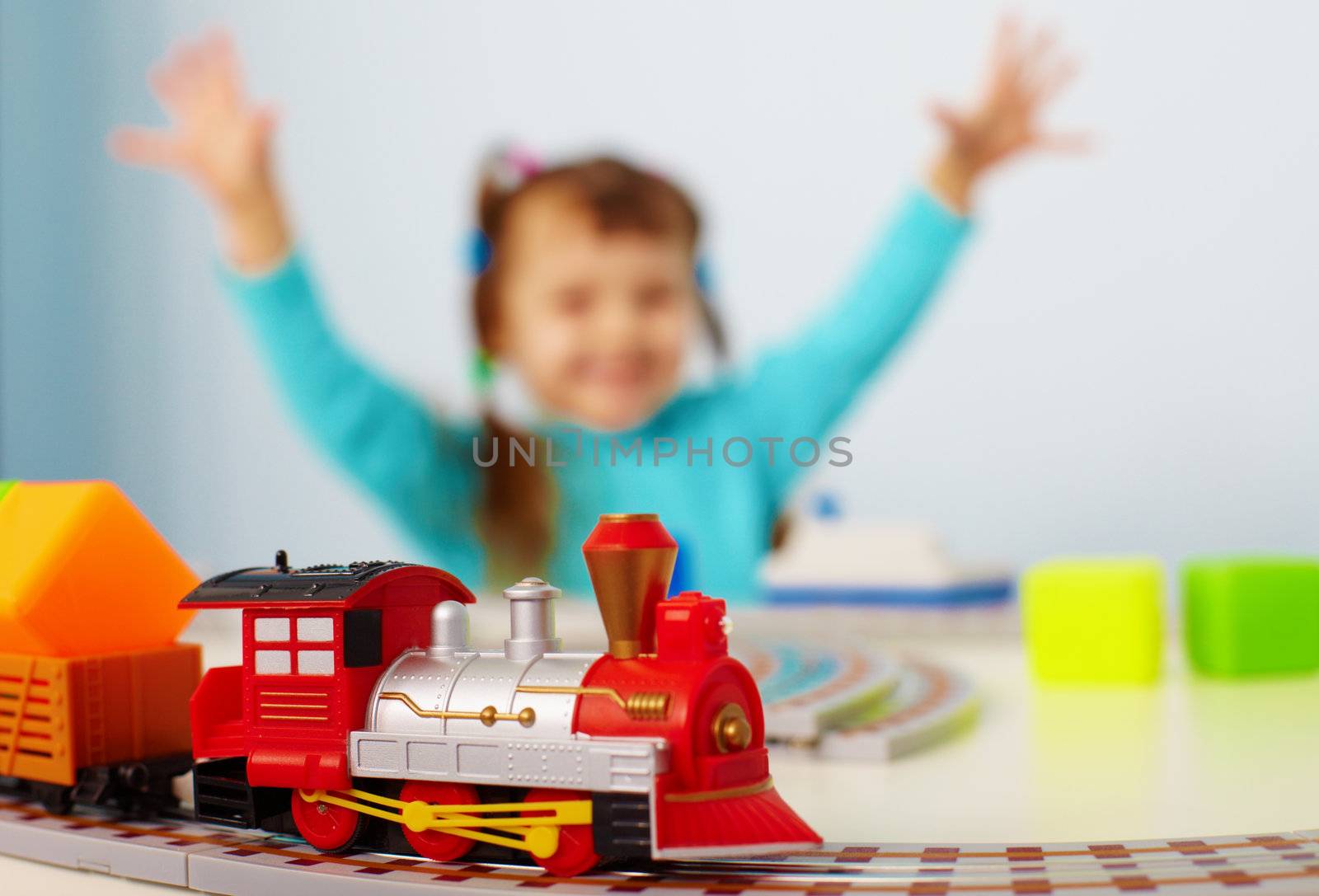 A happy child playing with a toy railway