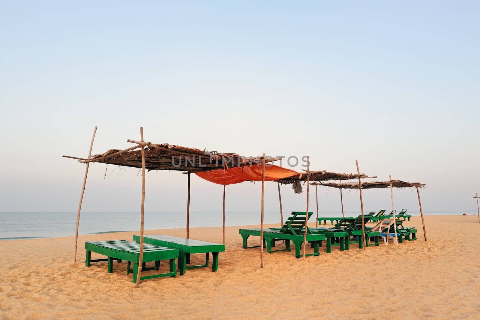 Exotic lean-tos of palm leaves on tropical beach