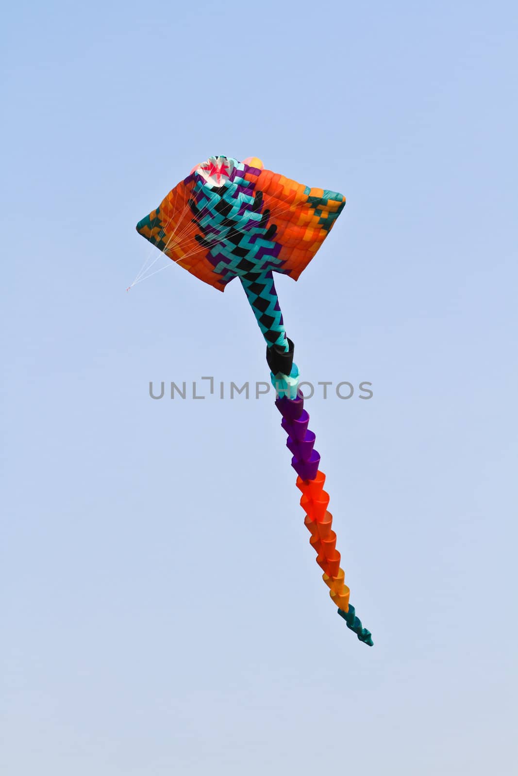 Multicolored kite in the blue sky