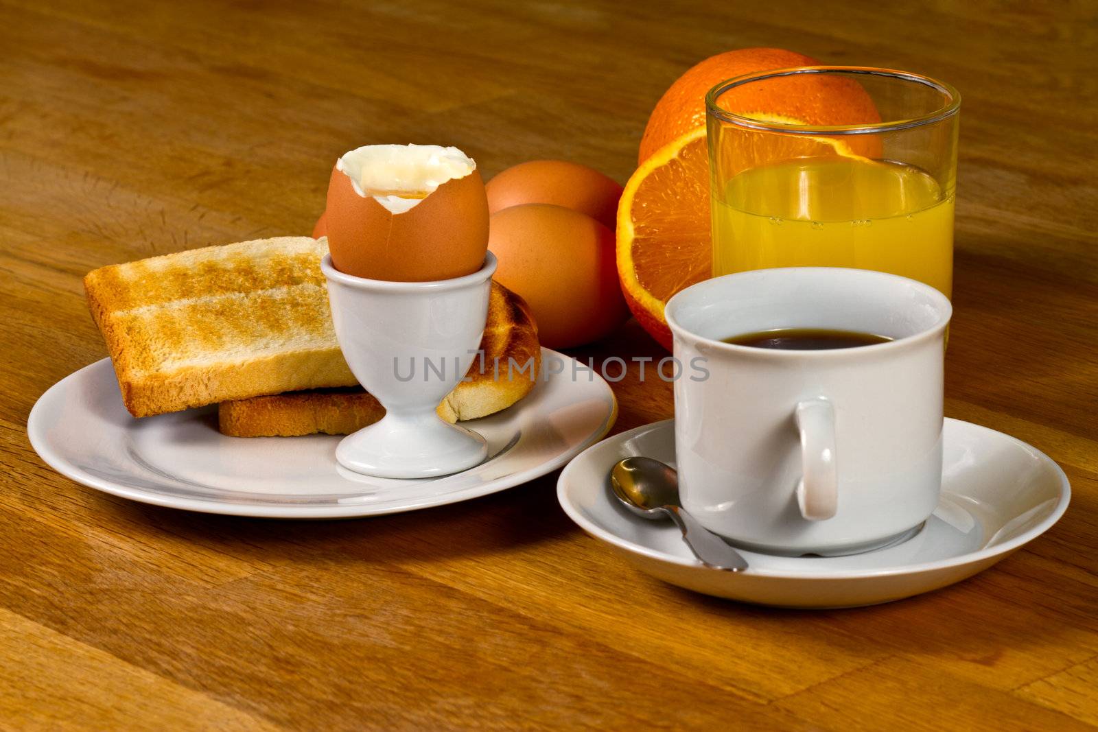 Breakfast: Boiled egg, toast, coffee and fresh orange juice. On Wooden table