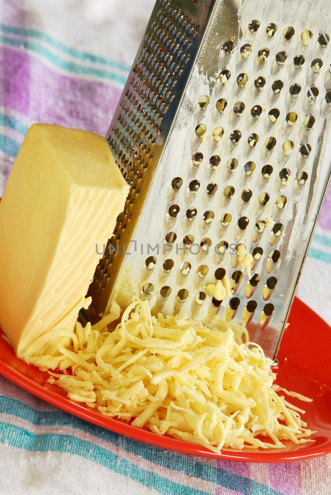 grated yellow cheese with a metal grater closeup